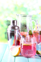 Pink lemonade in glasses and pitcher on table close-up