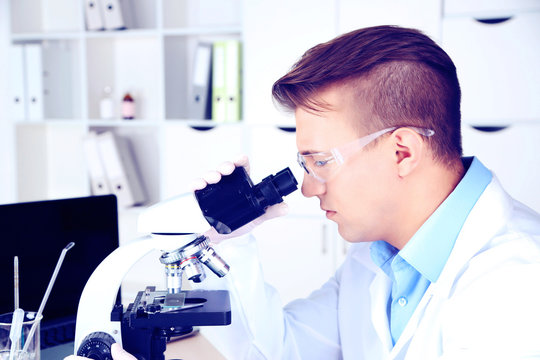 Young male researcher carrying out scientific research in lab