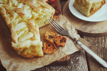 Apple pie on a board with fresh apples