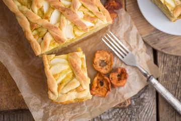 Apple pie on a board with fresh apples