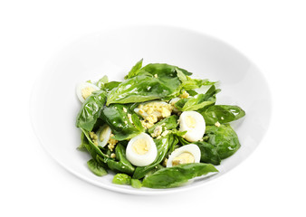 Salad with quail egg and basil in plate isolated on white