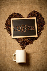 Concept photo of love to coffee with beans, mug and chalkboard