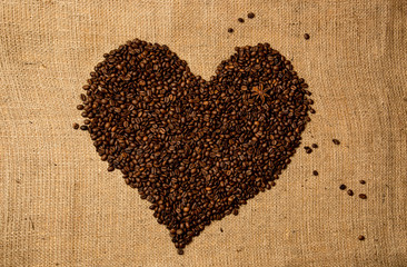 heart shape made of coffee beans on linen cloth