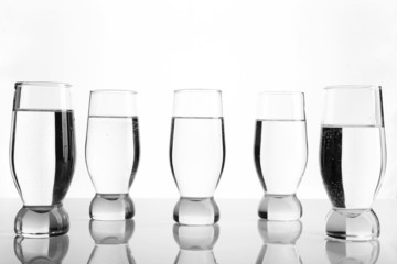 Glasses of water on light background