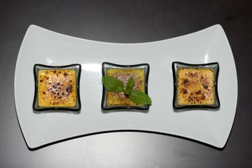 Obraz premium Plate of three creme brulees from above