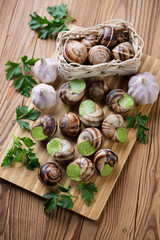 Escargots de Bourgogne on a wooden cutting board