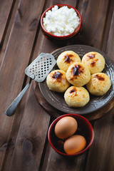 Curd pancakes with ingredients over rustic wooden background