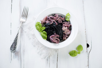 Glass plate with black tagliatelle and octopuses, studio shot