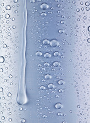 Water drops over blue glass background.