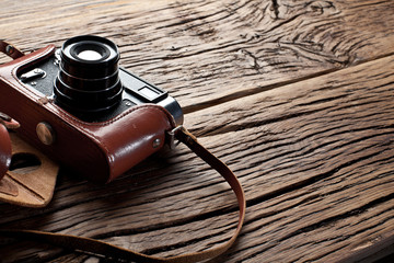 Old rangefinder camera on the old wooden table.