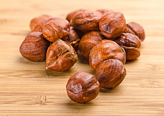 A pile of shell-less hazelnuts, isolated on textural wood backgr