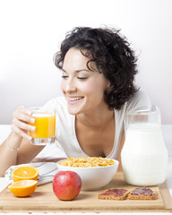 Woman drinking fresh orange juice for healthy breakfast on white