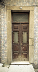 Fototapeta na wymiar Old wooden door with window on the wall with ceramic tile. Toned