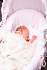 Newborn baby in a bassinet