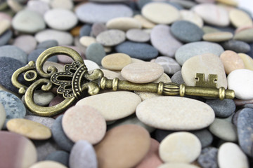 Old Brass key on a pebble beach