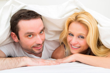 Portrait of a young happy couple in a bed