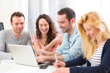Fototapeta premium Group of 4 young attractive people working on a laptop