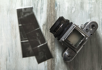 Old medium format camera and films on vintage wooden table