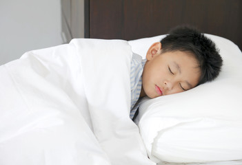 little boy sleeping in bed