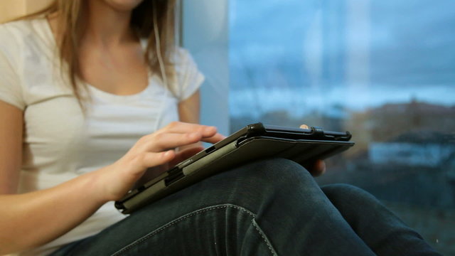 girl listening to music while sitting by the window