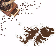 Coffee powder in the shape of Falkland Islands and a coffee mill
