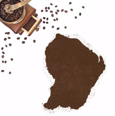 Coffee powder in the shape of French Guiana and a coffee mill.(s