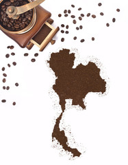 Coffee powder in the shape of Thailand and a coffee mill.(series