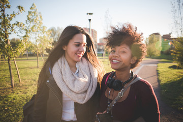 two multiethnic beautiful young woman black and white having fun