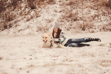 Funny portrait of young woman playing with labrador