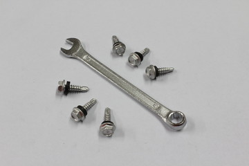 Wrench and screws on white background.