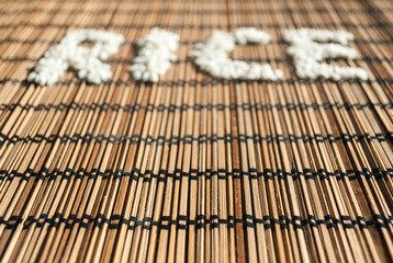 Word "rice" written on a wicker placemat with rice grains