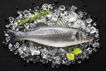 Fresh fish on ice on a black stone table top view - 76263069
