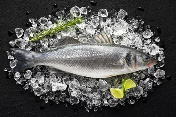Wall murals Fish Fresh fish on ice on a black stone table top view