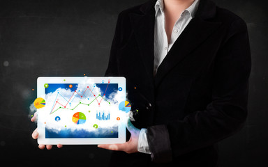 Person holding a touchpad with cloud technology and charts