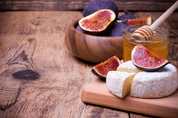 Camembert cheese with honey and figs on a wooden board. - Powered by Adobe