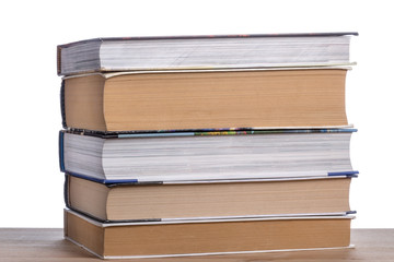 Stack of books on a wooden table.