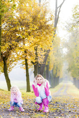 Fototapeta premium mother with her daughter in autumnal alley
