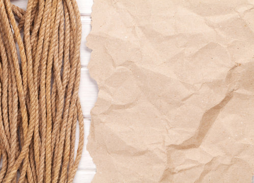 Brown rumpled cardboard paper background with marine rope