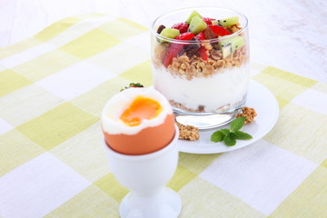 yogurt dessert with muesli and berries in small glass