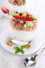 yogurt dessert with muesli and berries in small glass