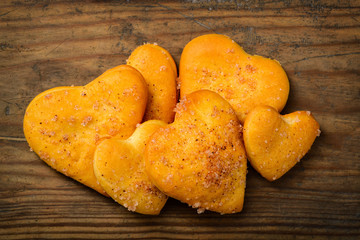 Heart-shaped cookies on wooden background.