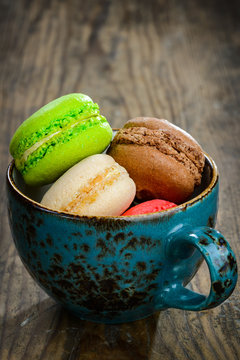 Sweet and colourful french macaroons on wooden background