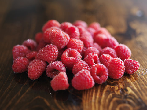 pile of raspberries on wooden table,