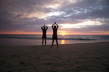 Yoga à deux au coucher du soleil