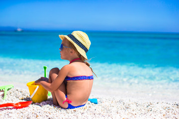 Adorable little girl playing with beach toys during tropical