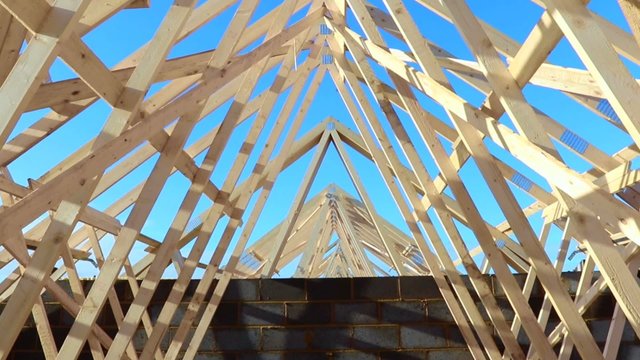 New residential construction home framing against a blue sky 