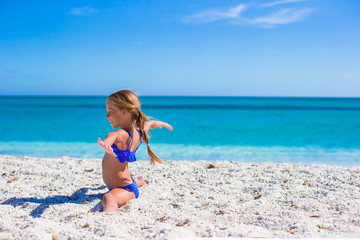 Happy little sporty girl on white tropical beach