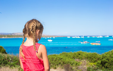 Little adorable girl enjoying beautiful view of turquoise sea