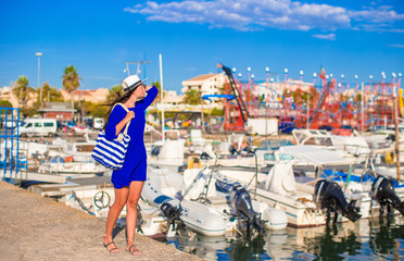 Fototapeta na wymiar Young beautiful woman walking on dock near the boat