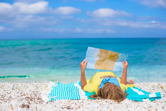 Adorable little girl with map of island on tropical beach